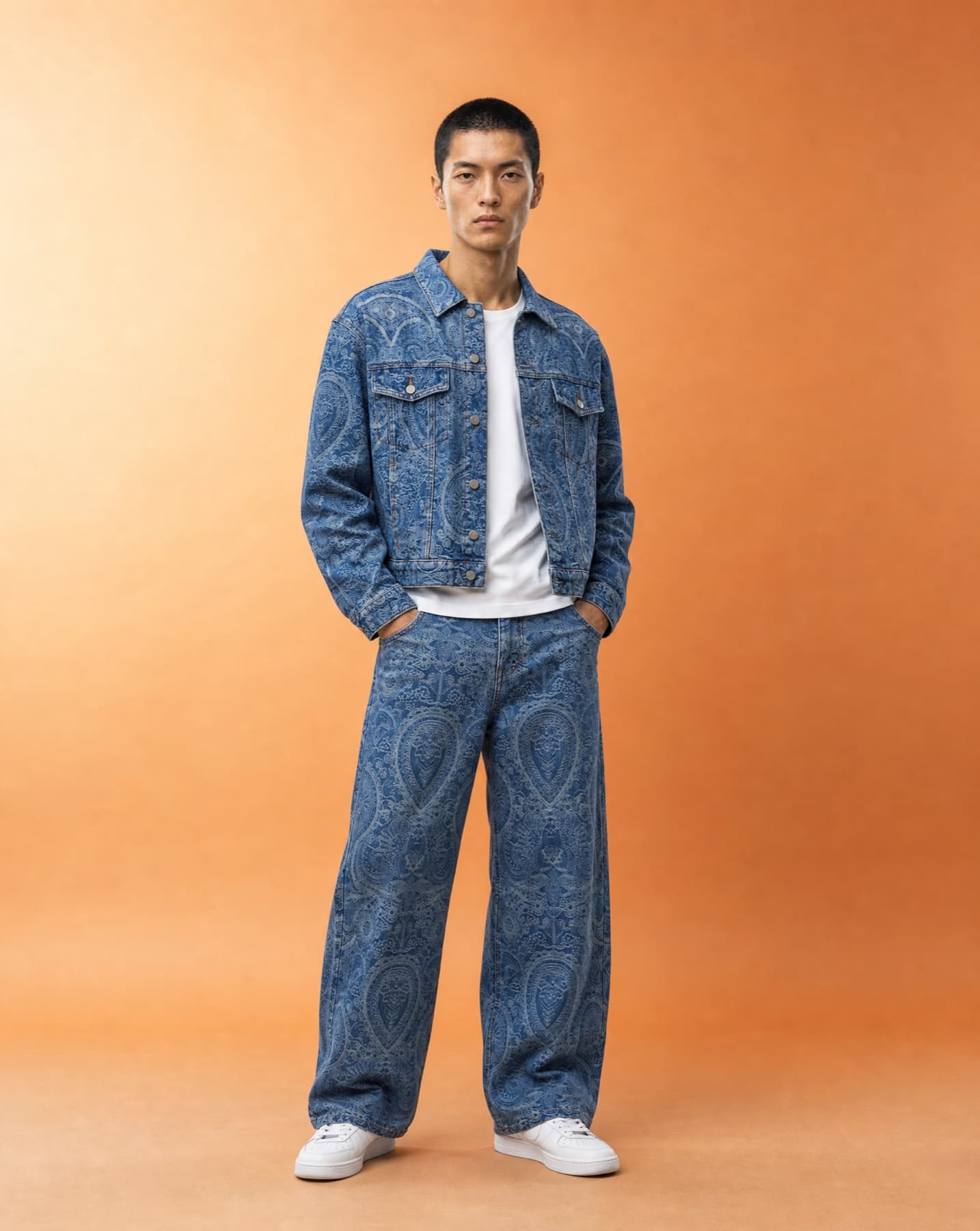 Full-length studio campaign image of a model in a blue paisley denim co-ord
