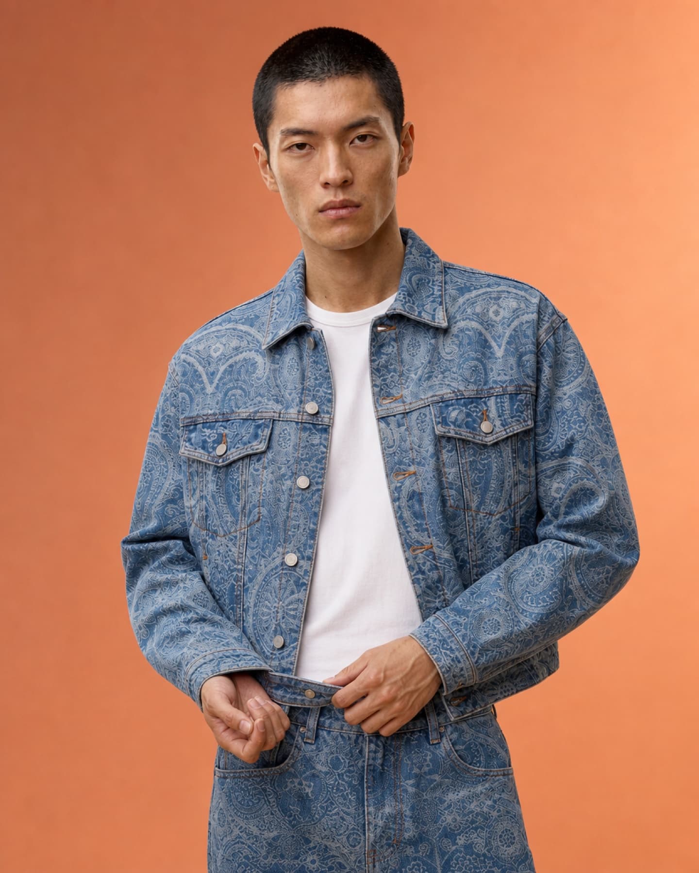 Mid-length studio portrait featuring the matching denim jacket and trousers