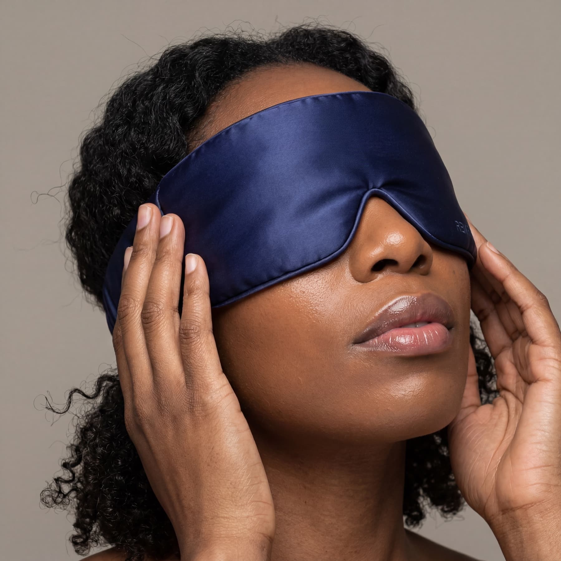 On-model close portrait featuring the REM Retreat midnight blue sleep mask