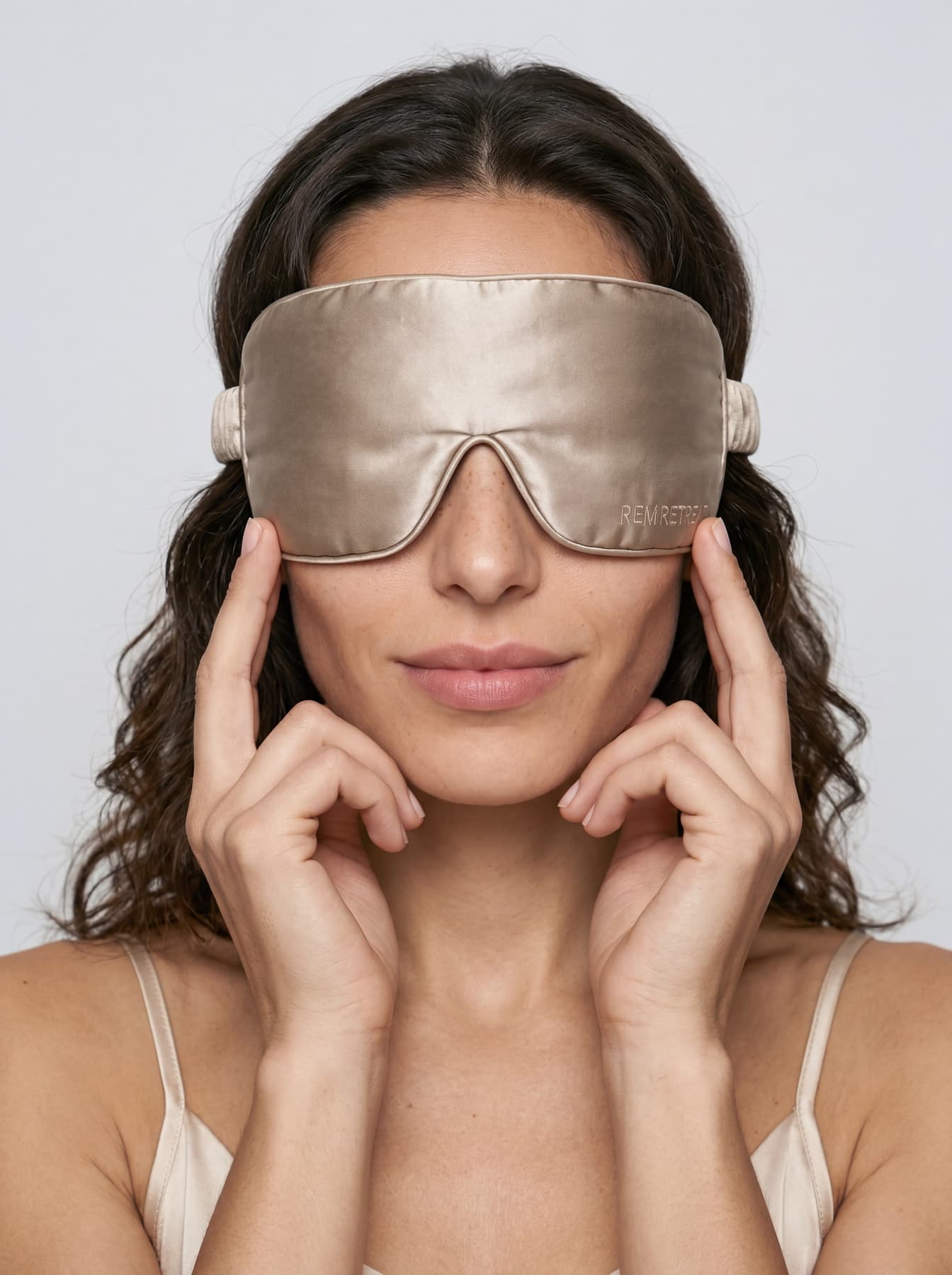 On-model portrait featuring the REM Retreat champagne sleep mask